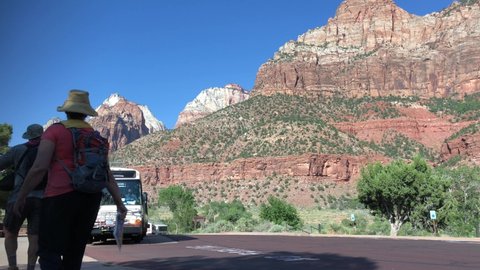 Utah, USA- July 2018: Visitors head to board the Zion National park free shuttle bus at one of the designated stops. 