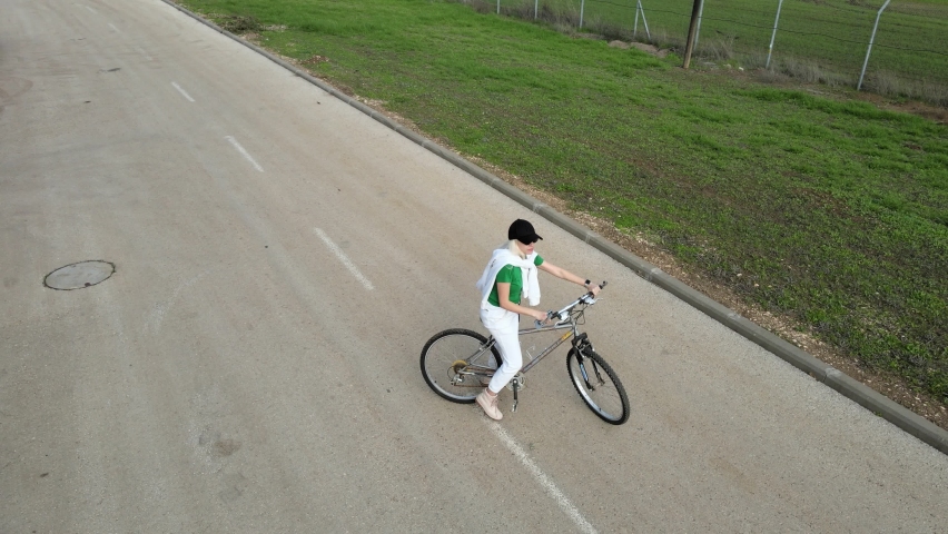 Happy loving couple riding bicycles on countryside road on warm summer evening