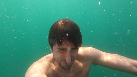 Man emerging into lake water surface