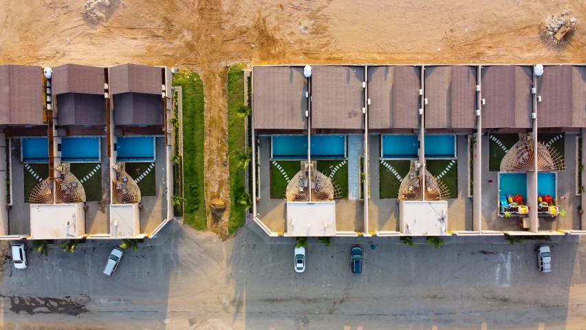Aerial top down, row of subdivided resort housing estate with backyard and pool