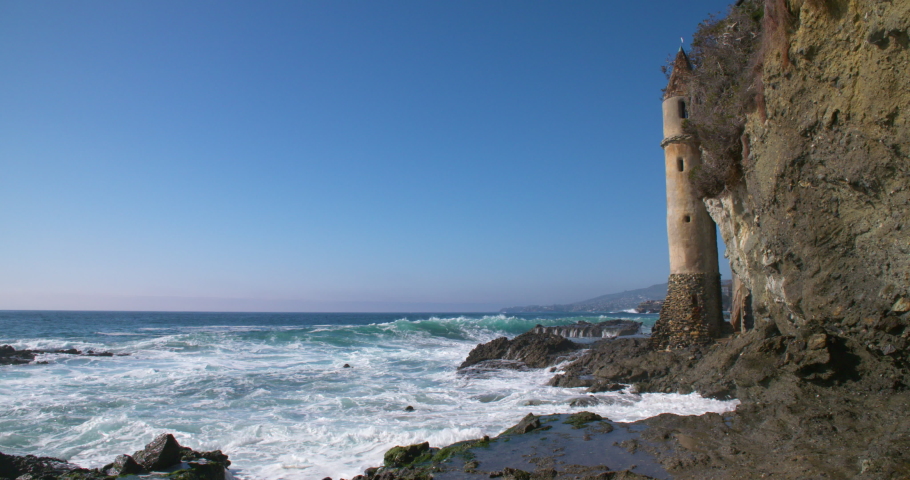 Picturesque view of waves splashing up against the Victoria Beach Pirate Tower in Laguna Beach, California.