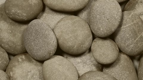Sepia brown pebbles rotation background texture. Loop motion