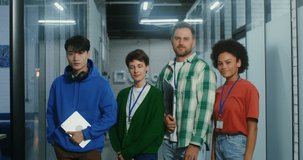 A group of handsome young people of different nationalities are smiling looking at the camera while standing in the modern office. Startup team, video portrait. 4K video, red komodo