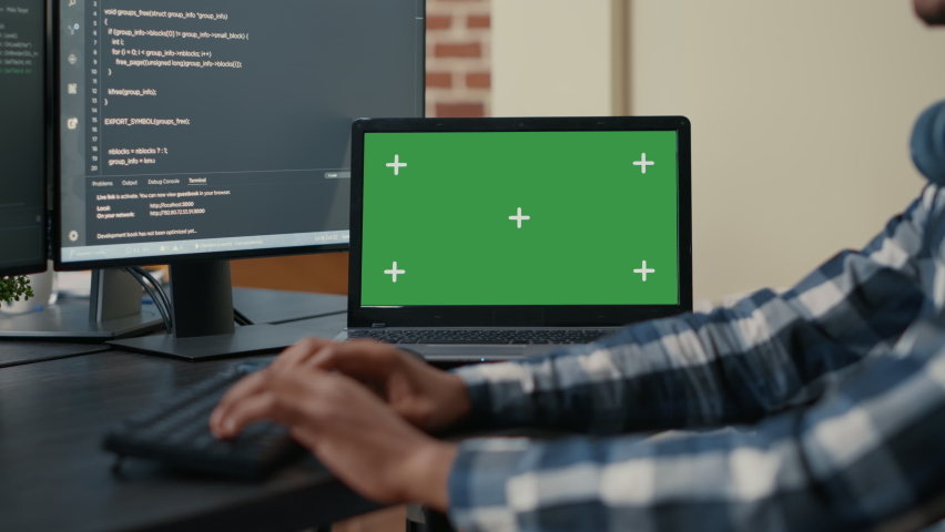 Closeup of laptop with green screen chroma key mockup and african american hands writing code on computer keyboard. Programer developing software in front of multiple screens running ai algorithm. Royalty-Free Stock Footage #1085169788