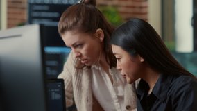 Team of software engineers talking about source code running on laptop screen while sitting at desk in it development office. Programmers collaborating on data coding group project. - Powered by Shutterstock - Get 15% off with code: PIKWIZARD15