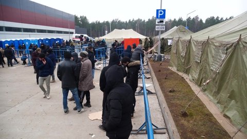 Grodno, Belarus - 12.03.2021 Exclusive footage of a Migrant camp in Belarus on the Polish-Belarus border. Outside the camp. Daily routine of the migrants. Migrants standing in a line to get food