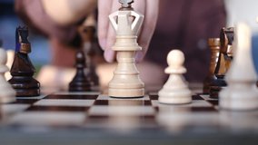 unrecognizable woman playing chess. pawn defeats a king in a chess game. strategy, management or leadership concept. slow motion video.