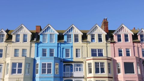 Aldeburgh, Suffolk. UK.  January 6th 2022. Tilt shot of the coloured buildings on Crag Path on the seafront on a sunny day with blue sky.  