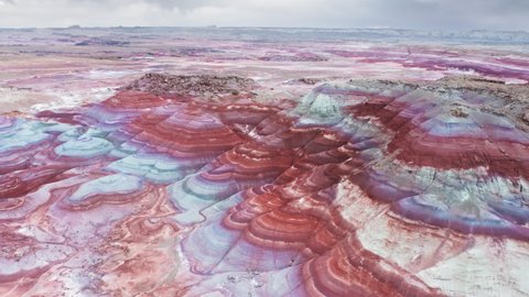 Aerial drone view of ancient seabed with colorful mineral pattern and texture in vibrant saturated colors of pink, blue, purple, red, orange. Fantasy, surreal, unearthly, nature landscape background