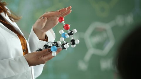 A female chemistry teacher holding a molecular model, close up of the molecular model Stock Video