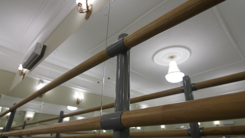 Wooden bars near large mirror in spacious ballet dance classroom with vintage luster and decorated ceiling close view Royalty-Free Stock Footage #1085179781