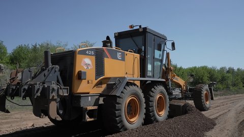 September 3, 2021, Russia, Orenburg.
LiuGong 425-4WD CLG grader leveling the road with the bottom blade.
