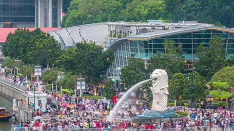 SINGAPORE - CIRCA JAN 2020: Aerial view of central Singapore. Merlion fountain sculpture with financial towers on background timelapse. People walking around