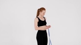 Weight Loss Concept. Young Fit Woman In Sportswear Measuring Waist And Hips After Training In Studio, Happy Excited Sporty Millennial Female Standing Over White Background, Slow Motion Footage