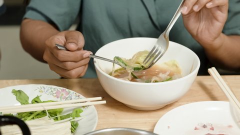 4k, Close Up A sukiyaki bowl with a woman's hand using a spoon to prepare it for eating.