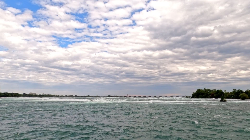 Wide shallow river rapids flowing and churning. at Niagara Falls, Ontario, Canada.
