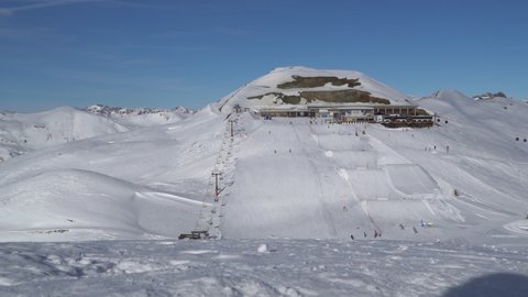 Livigno, Italy - January 2, 2022 - panoramic view of skiers on slopes at Carrosello Station in the ski resort of Livigno
