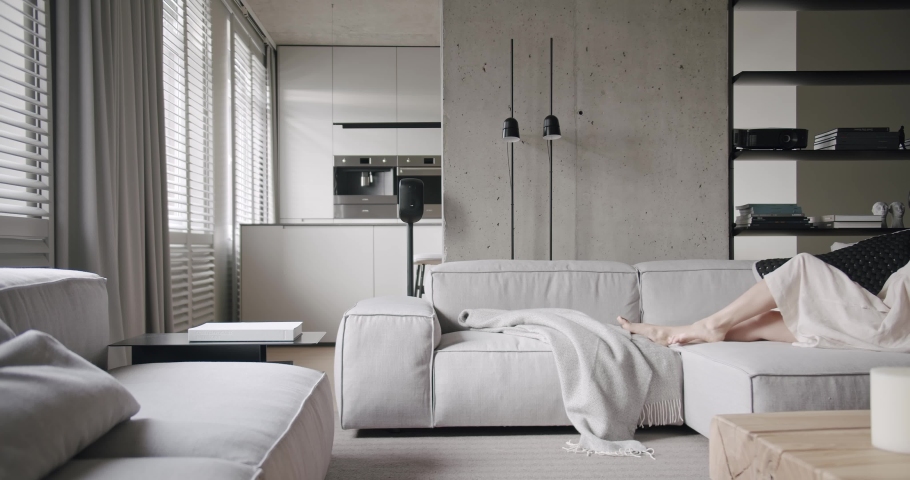 Woman rests at Modern Home. Living Room. Minimalist Design with concrete. Royalty-Free Stock Footage #1085194247