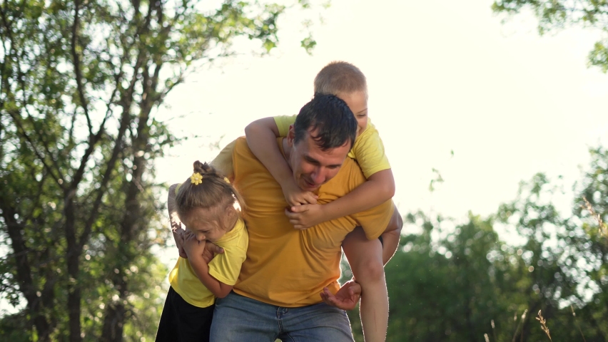 Happy family in the park. The parent throws the son's child up. Father plays with his son outdoors in the grass. Happy family fun in the park in summer. Young parent father playing with children Royalty-Free Stock Footage #1085195993