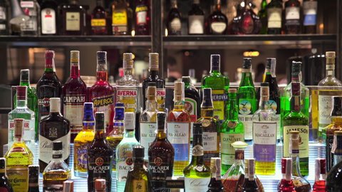 May 11, 2021, Kyiv, Ukraine
alcohol bottles in a restaurant bar. many spirits stand in rows on the shelf bar room area. strong alcohol different trade marks and expensive brands. dolly shot, close up