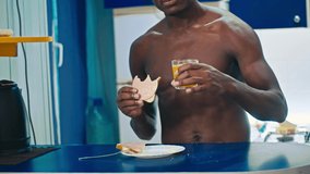 Happy black guy eating breakfast at home