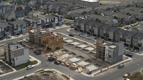 Aerial flyover view of frames and foundations of houses under construction - American Fork, Utah, United States