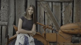 Portrait of confident teenage girl leaning on tractor - Pleasant Grove, Utah, United States