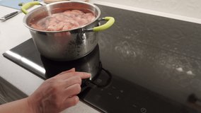 Cooking on electric stove top in the kitchen, shrimp are boiled in a saucepan on induction cooktop closeup. High quality 4k footage