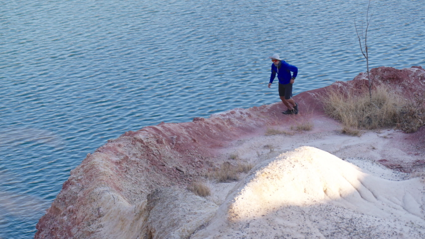 Asian trail runners running outdoors in the sand dunes during summer daytime.