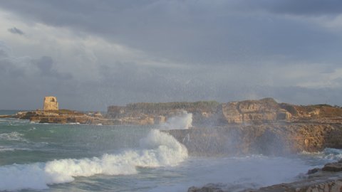 The too much camera shake due to the extreme shooting conditions. Sea power. Strong waves crash against coastal rocks in windy weather. 