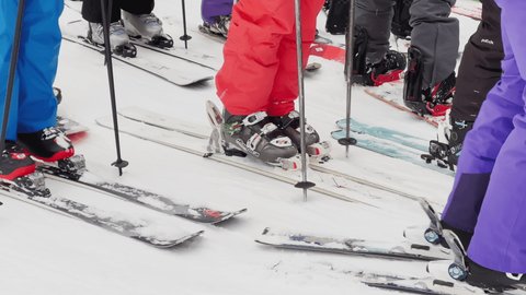 Russia, St. Petersburg, 03 January 2022: feet of skiers and snowboarders in line at the ski lift to the ski slopes of the ski resort at weekend