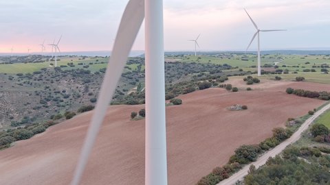 Aerial view of a wind farm on clay strata of different colors filmed by drone in spring during sunset in Guadalajara in Spain.