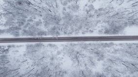Aerial top down drone shot of Snowy forest road and cars on it. Forest road from above. White background. Diagonal highway. Minimalism concept 4k video