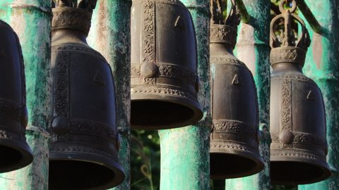 Close up of traditional buddhist bronze bells hanging at a buddhist temple in thailand.