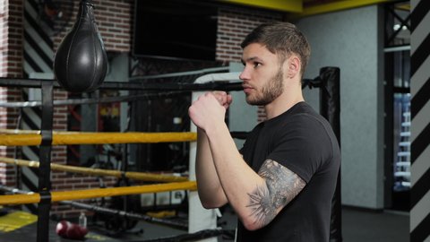 Brutal tattooed boxer who trains in the ring and hits a punching bag.
