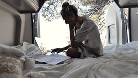 Woman working online from her Camper van.View of woman working on her laptop from a wild camping spot, Croatia. Digital nomad lifestyle