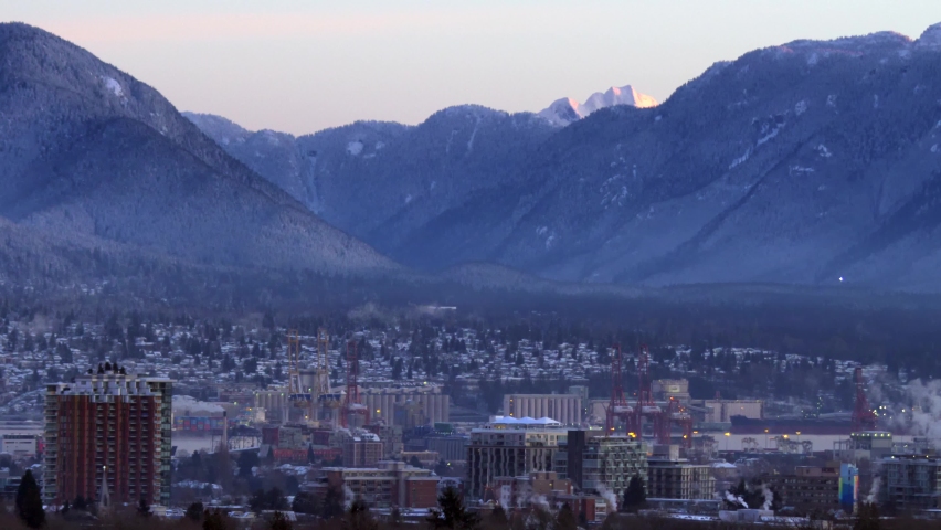 Stunning cityscape of Vancouver at sunset, surrounding mountains. Static
