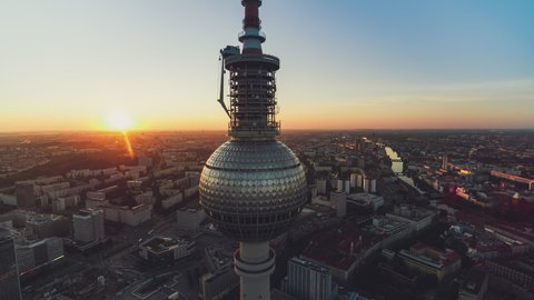 Berlin, France - circa 2021 - Establishing Aerial View Shot of Berlin, Germany, capital city, circling around TV Tower, sunrising sun warm heart