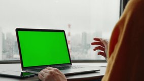 People using a laptop PC in the room. Green screen for chroma key composition. - Powered by Shutterstock - Get 15% off with code: PIKWIZARD15