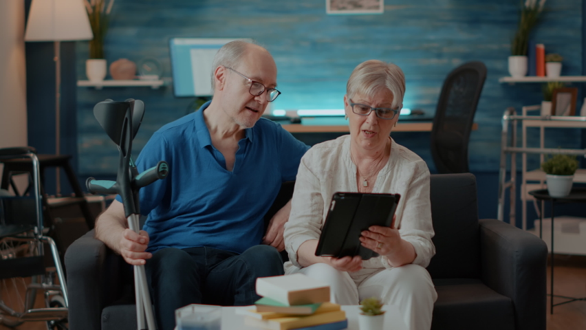 Senior couple waving at tablet webcam on online video call, enjoying remote conversation with relatives. Husband and wife chatting with people on teleconference, using digital gadget. Royalty-Free Stock Footage #1085228684