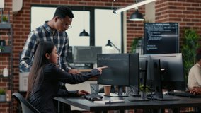Mixed team of software developers analyzing source code pointing at screens comparing algorithm with user interface on digital tablet. Programmers working on coding group project sitting at desk. - Powered by Shutterstock - Get 15% off with code: PIKWIZARD15