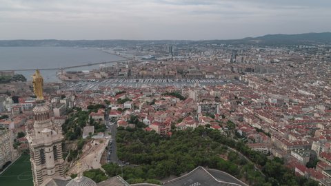 Establishing Aerial View Shot of Marseille Fr, Bouches-du-Rhone, Provence-Alpes-Cote d'Azur, France, push into the port, day overcast