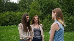 Three friends, young girls, having fun in park, slow motion.