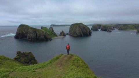 Traveler Standing on a Cliff and Lokking on Beautiful Unnamed Bay, Shikotan Island, Lesser Kuril Chain, Coastline of Pacific Ocean, Russia. Drone Shot.