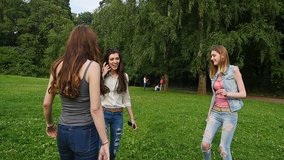 Three friends, young girls, having fun in park, slow motion.