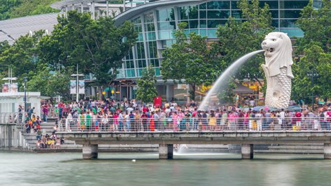SINGAPORE - CIRCA JAN 2020: View of central Singapore. Merlion fountain sculpture with financial towers on background timelapse. People walking around