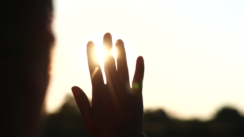 Women stretches hands against the sun beams with beautiful sunset or sunrise in nature background. Happy Family , Mothers Day, Childrens Day Concept.