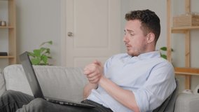 Guy sit on comfy sofa leaned on cushion put laptop on laps talk by video conference application. Business from home, online counselling, chat share news to friend concept