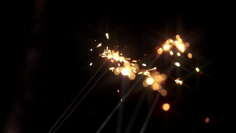 Celebrating the event with bright sparklers of fireworks in the hands of people glowing in night super slow-motion close-up. Party to celebrate wedding, birthday or new year. Happy holiday.
 Stock Video