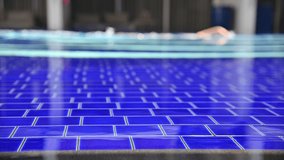Side view video of swimming pool. water wave on tile of swimming poolside